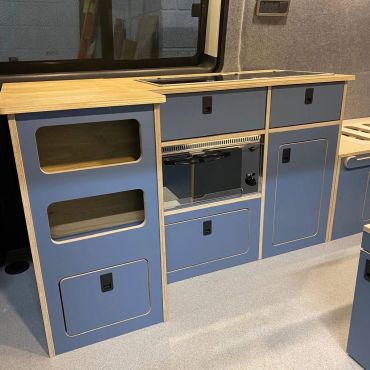 Modern kitchen cabinets with wooden tops and blue fronts.