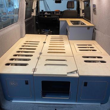 Custom campervan interior with built-in storage and kitchen.