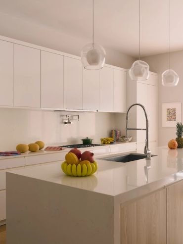 Modern kitchen with white cabinets and fruit centerpiece.