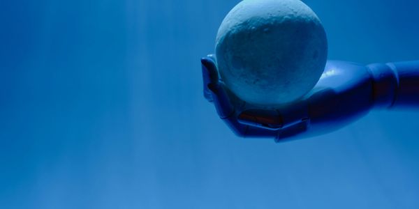 A robotic hand holding a glowing sphere, representing human-AI collaboration and next-gen