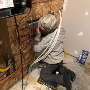 Brad’s son, Elion, learning to install boiler headers. 