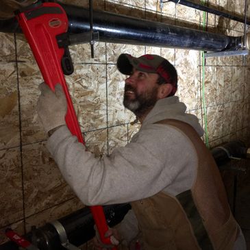 Brad using a huge pipe wrench. 