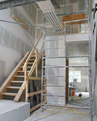 Front entrance way under construction, temp stairs and tall ceilings