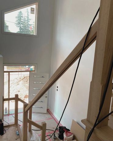 Looking down a staircase, into the foyer of a custom build in Cambridge 
