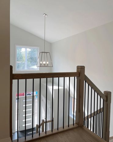 Looking into a front foyer from above, large windows and brushed gold light fixtures