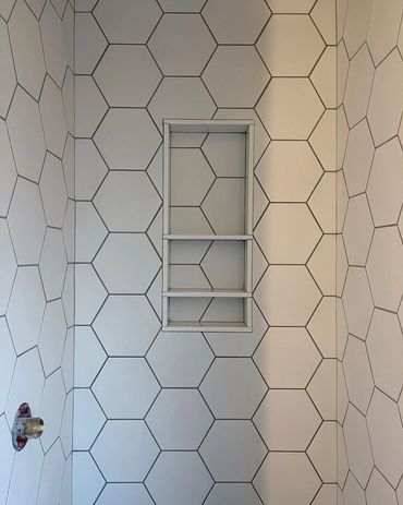 Freshly tiled shower with a hexagon tile, matched through the niche. Waterproofed with Schluter