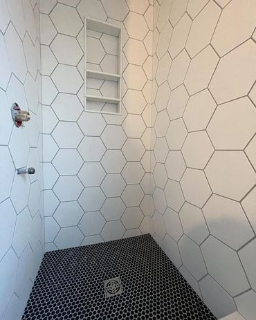 Freshly tiled shower with a hexagon tile, matched through the niche. Waterproofed with Schluter