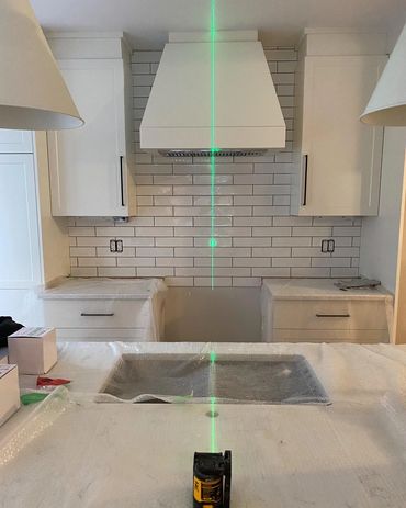 Perfect alignment between the island in the sink, stove and range hood. in a custom kitchen we built