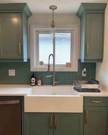 Very welcoming light green kitchen with matching bead board backsplash. Brushed gold hardware