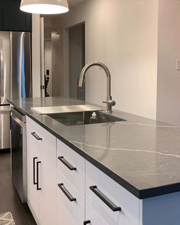 Long island with dark counter tops and white veining in the stone. Built in Pioneer Park