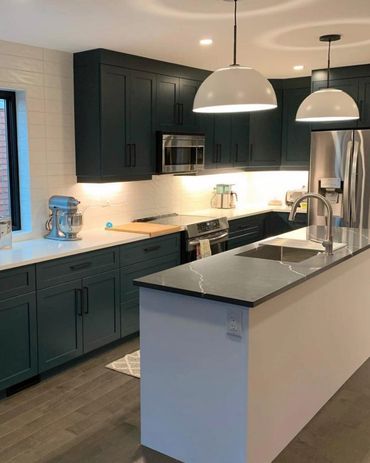 Beautiful dark green kitchen with white island cabinets. Stainless appliances, contrasting counters 