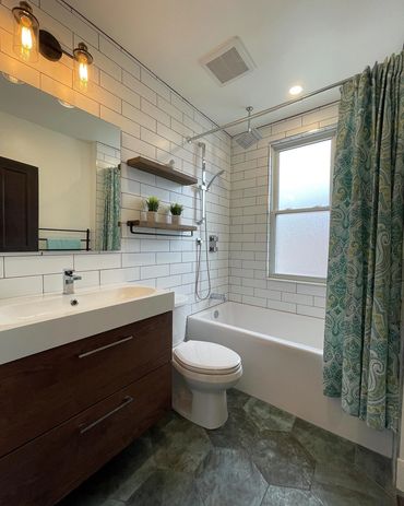 Natural colours and lighting, matched with light brown grout and floating wood vanity make this pop