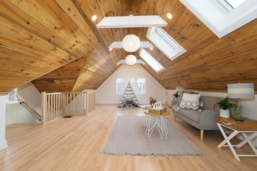 Attic conversion with reclaimed wood ceiling and skylights. Natural maple hardwood flooring 