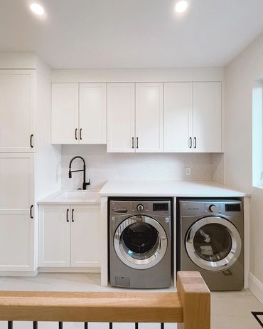 Custom laundry room, with white cabinets and counters, subway tile backsplash 