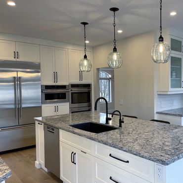 Oversized island with lots of built in appliances. Glass pendent lights and granite counters 