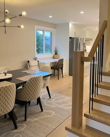Custom staircase and railing in white oak and black metal spindles. Looking into Dining room.