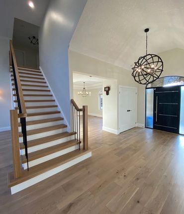 Main floor renovation completed with beautiful open staircase and oversized front door 