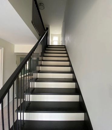 Black and white restored staircase in a century home that we renovated in Kitchener 