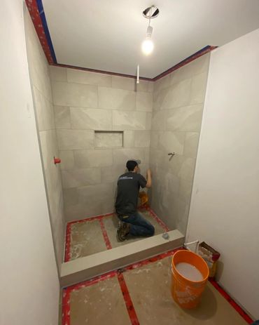 Custom shower being tiled in a basement renovation we completed in waterloo. 