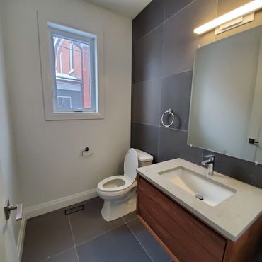 Modern grey tiled powder room, with a walnut floating vanity with a MCM feel. Led lighting