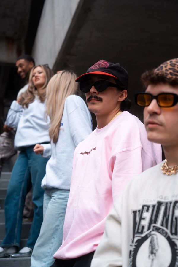 group of people standing in crewnecks