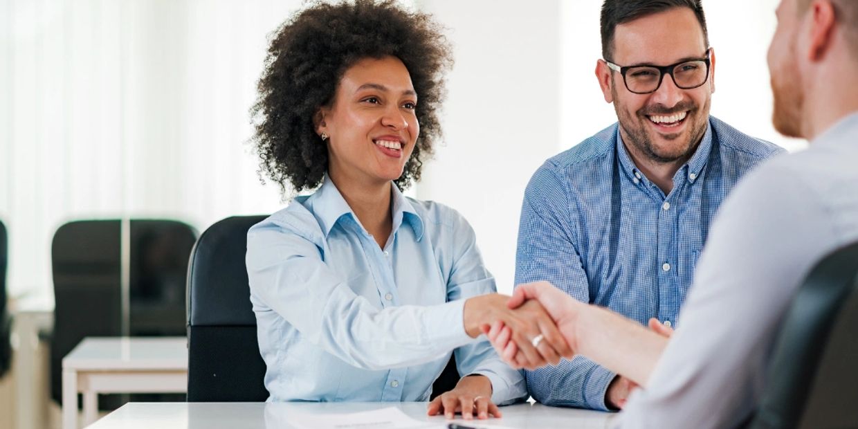 Two people shaking hands in a business meeting.