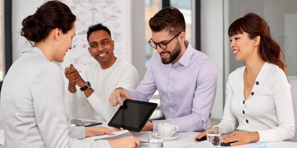 Four colleagues having a meeting with a tablet in an office.