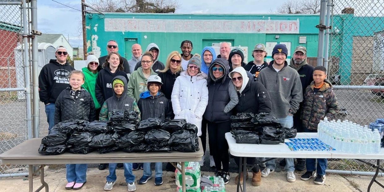 Group of volunteers with packed supplies outside a rescue mission.