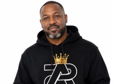 Man wearing a black hoodie with a crown graphic.