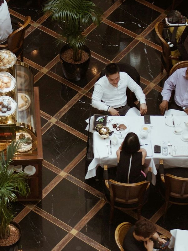 People dining at a restaurant with elegant black and brown tiled floor.