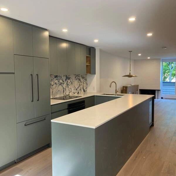 Modern kitchen with green cabinetry and a large island.