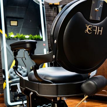 Close-up of a sleek, black exercise machine seat in a gym.