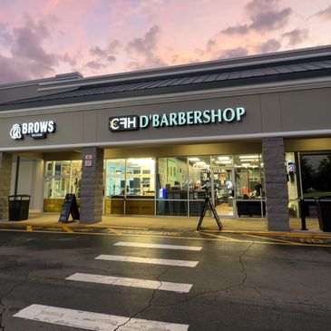 Exterior of EH D'Barbershop and Brows Studio at dusk.