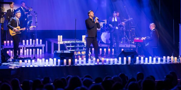 Band performing on stage with candles.