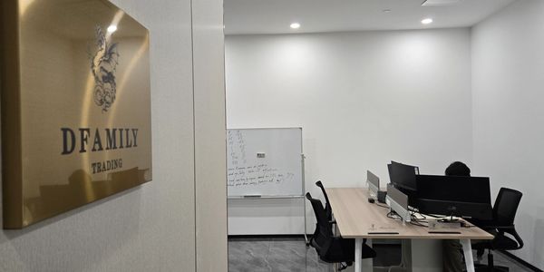 Modern office space with desks, chairs, and a whiteboard, labeled DFAMILY TRADING.