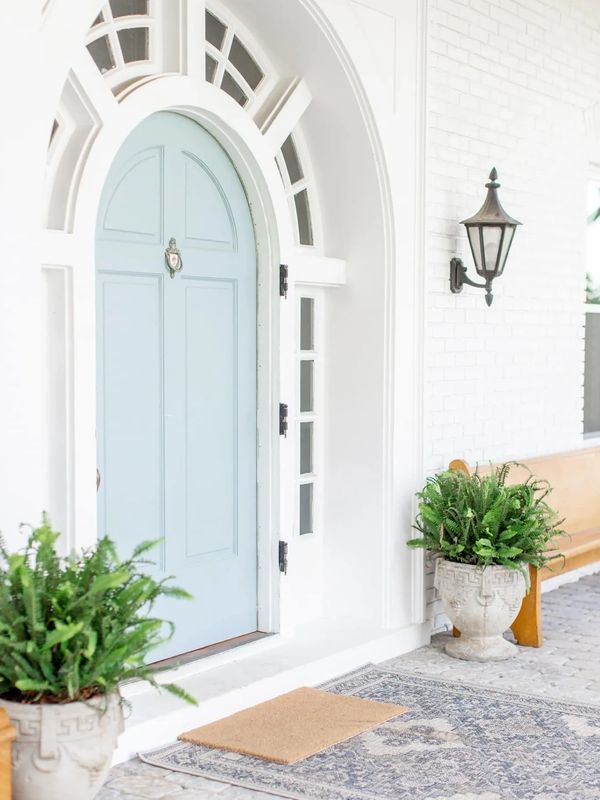historic mansion front door with arched windows and ferns