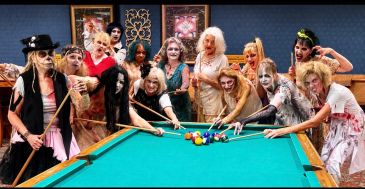 Group dressed as zombies playing pool.