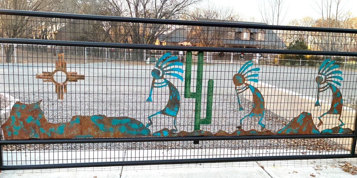 Privacy gate with decorative Kokopelli and Zia 