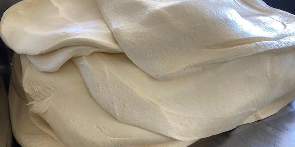 Close-up of folded white fabric with subtle texture and patterns.