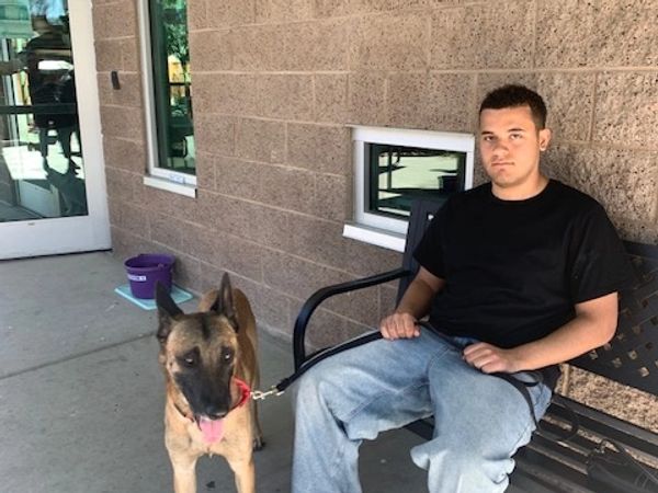 A man sitting on a bench with a dog.