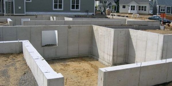 Freshly poured interior and exterior concrete walls setting for a new home construction build.