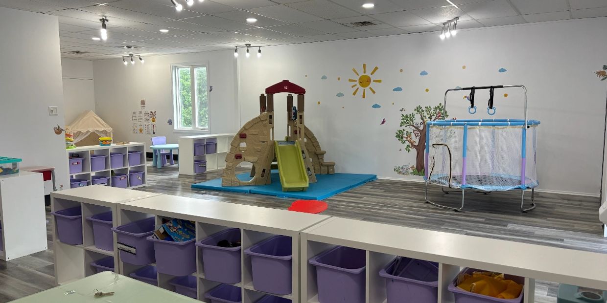 Bright and organized children’s playroom with slide, trampoline, and storage bins.