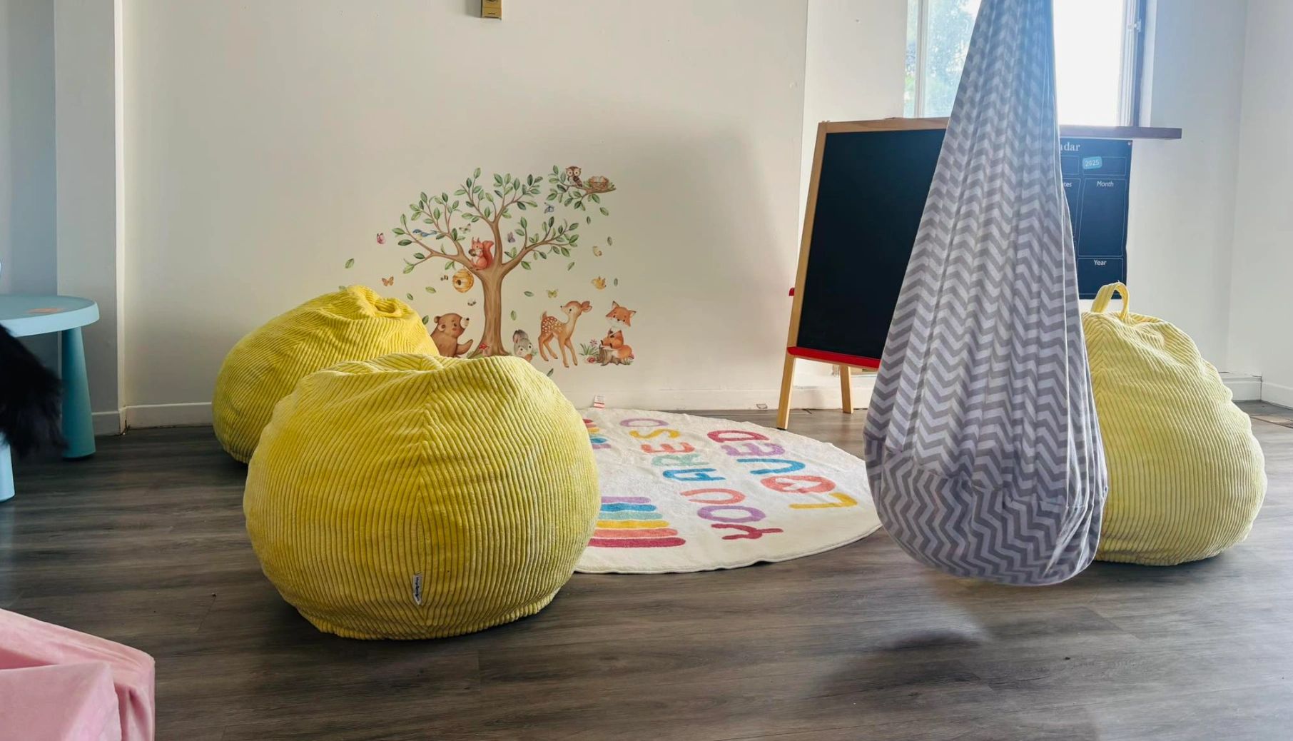 Cozy children's playroom with yellow bean bags and a playful animal wall decal.