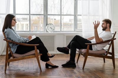 Female Therapist Talking to Male Patient, Anxiety, Depression Treatment Cognitive Behavioral Therapyo