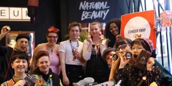 A group of trans people post together holding LUSH beauty products and a gender swap sign