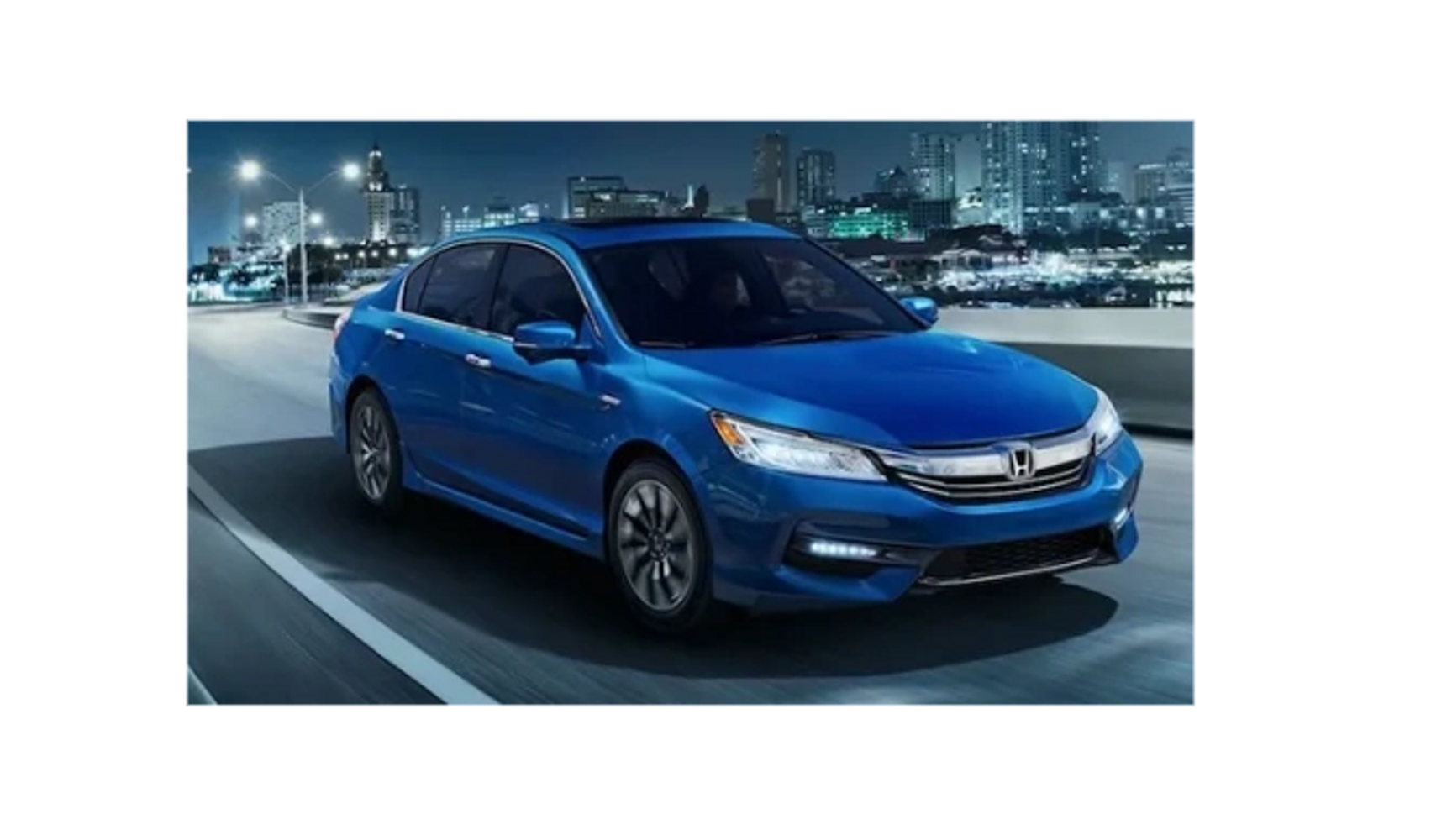 Blue Honda sedan driving on a city road at night.