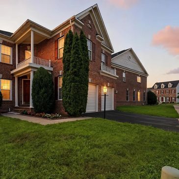 Brick suburban house with garage at sunset.