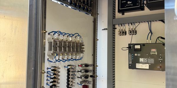 Electrical control panel with wiring and battery charger components.