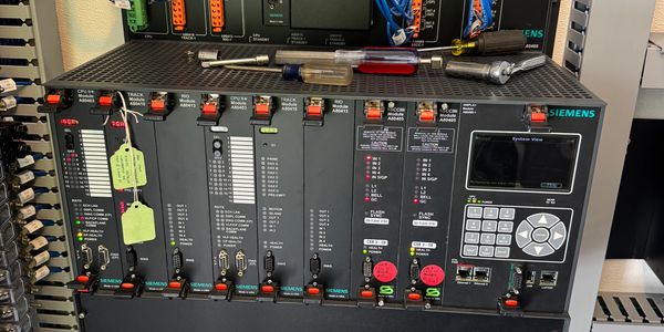 Siemens industrial automation control panel with multiple modules and tools on top.