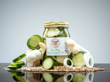Jar of pickles with garlic and onion slices.